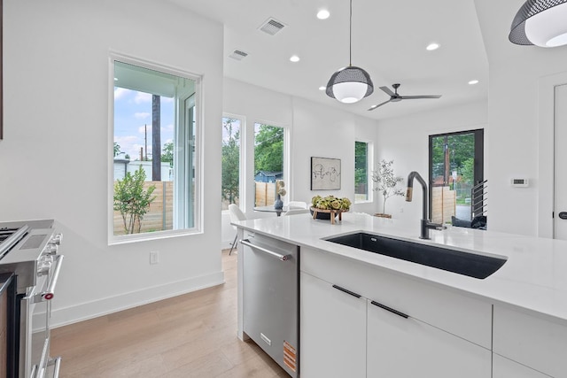 54 Robert T Martinez Jr St, Austin, TX 78702 - kitchen with appliances with stainless steel finishes, recessed lighting, light wood-style flooring, ceiling fan, and decorative light fixtures