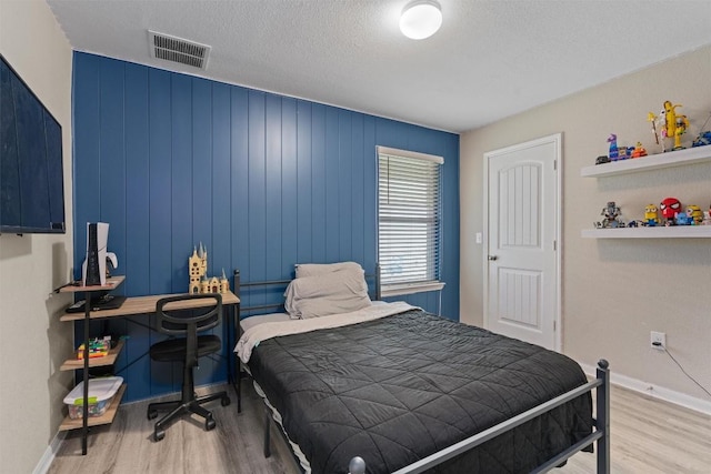 3402 Tilmon Ln, Austin, TX 78725 - bedroom featuring wood finished floors and a textured ceiling