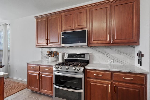 4201 Veiled Falls Dr, Pflugerville, TX 78660 - kitchen featuring appliances with stainless steel finishes, decorative backsplash, and brown cabinets