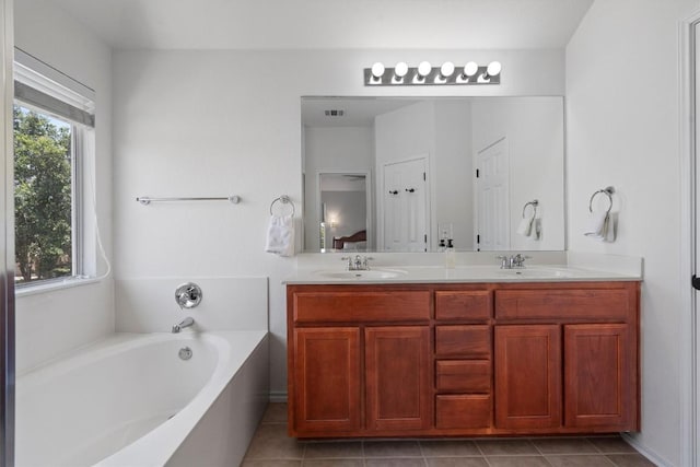 4201 Veiled Falls Dr, Pflugerville, TX 78660 - bathroom with plenty of natural light, a bath, double vanity, and tile patterned floors