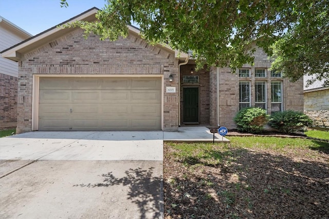 4201 Veiled Falls Dr, Pflugerville, TX 78660 - view of front facade with a garage, brick siding, and driveway