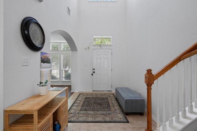 4201 Veiled Falls Dr, Pflugerville, TX 78660 - foyer entrance with a towering ceiling, healthy amount of natural light, stairs, arched walkways, and light tile patterned floors