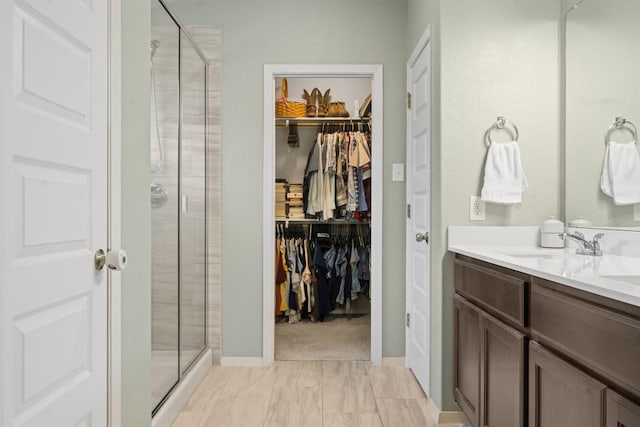 1703 Omaha Dr, Lago Vista, TX 78645 - bathroom featuring a shower stall, a walk in closet, and double vanity