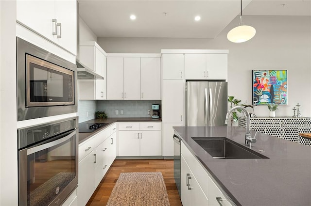 5921 Hiline Rd Unit 2404, Austin, TX 78734 - kitchen with stainless steel appliances, dark countertops, dark wood-type flooring, backsplash, and hanging light fixtures