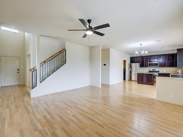 11509 Timber Heights Dr, Austin, TX 78754 - unfurnished living room with a chandelier, light wood-style flooring, a ceiling fan, and stairway