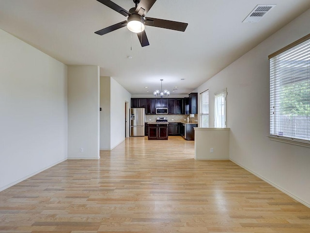11509 Timber Heights Dr, Austin, TX 78754 - unfurnished living room featuring a chandelier, light wood finished floors, and ceiling fan
