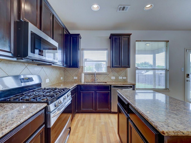 11509 Timber Heights Dr, Austin, TX 78754 - kitchen featuring stainless steel appliances, light wood-style flooring, light stone counters, recessed lighting, and tasteful backsplash