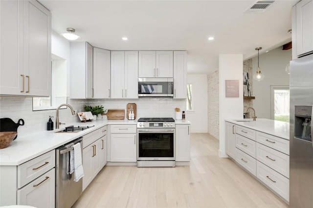 12044 Lincolnshire Dr, Austin, TX 78758 - kitchen featuring appliances with stainless steel finishes, tasteful backsplash, light countertops, light wood finished floors, and recessed lighting
