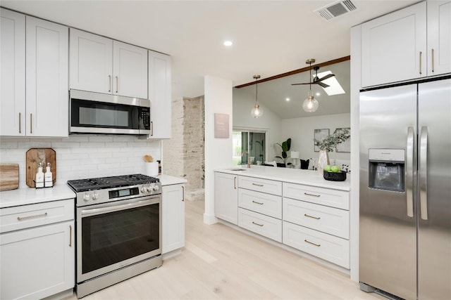 12044 Lincolnshire Dr, Austin, TX 78758 - kitchen with appliances with stainless steel finishes, ceiling fan, decorative backsplash, light countertops, and vaulted ceiling