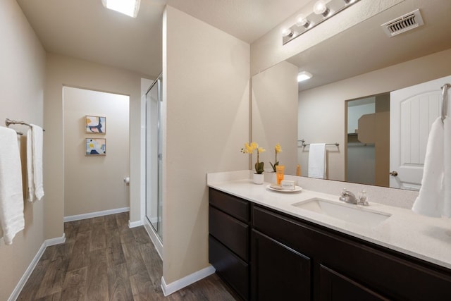 3305 Tilmon Ln, Austin, TX 78725 - full bathroom featuring wood finished floors, vanity, and a stall shower