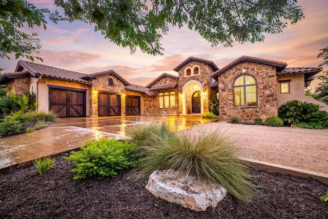 908 Watercliffe Dr, Lago Vista, TX 78645 - mediterranean / spanish home with stone siding, a garage, and a tile roof