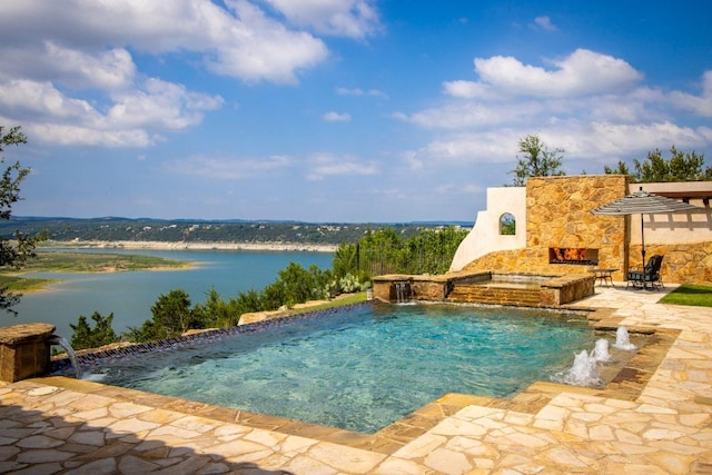 908 Watercliffe Dr, Lago Vista, TX 78645 - view of swimming pool featuring a patio area, an outdoor stone fireplace, a water view, and a pool with connected hot tub