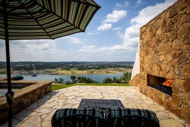 908 Watercliffe Dr, Lago Vista, TX 78645 - view of patio / terrace with an outdoor stone fireplace and a water view