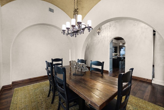 908 Watercliffe Dr, Lago Vista, TX 78645 - dining area with arched walkways, hardwood / wood-style flooring, a chandelier, and vaulted ceiling