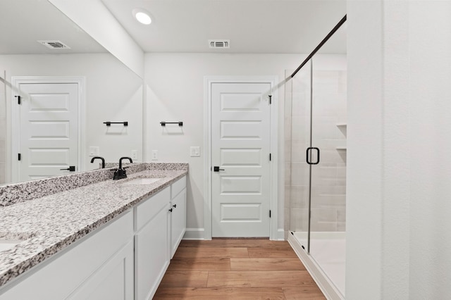 9509 Demure Dr Unit 4, Manor, TX 78653 - full bathroom featuring double vanity, wood finished floors, and a stall shower