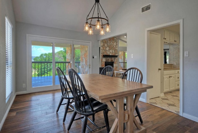13111 Mansfield Dr, Austin, TX 78732 - dining room featuring vaulted ceiling, hardwood / wood-style floors, a chandelier, and a fireplace