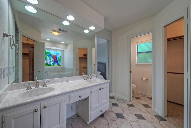 13111 Mansfield Dr, Austin, TX 78732 - full bathroom with a spacious closet, double vanity, recessed lighting, and a bathtub