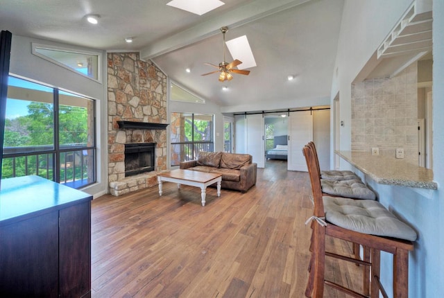 13111 Mansfield Dr, Austin, TX 78732 - living area with a skylight, wood-type flooring, a stone fireplace, and ceiling fan