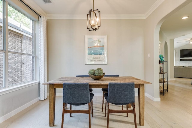 4105 Canyon Glen Cir, Austin, TX 78732 - dining area with arched walkways, light wood finished floors, crown molding, and a chandelier
