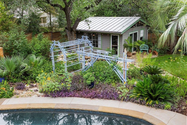 2606 Rockingham Dr, Austin, TX 78704 - rear view of property with a standing seam roof, an outdoor pool, and a metal roof