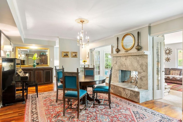 2606 Rockingham Dr, Austin, TX 78704 - dining area with wood finished floors, crown molding, a premium fireplace, and a chandelier