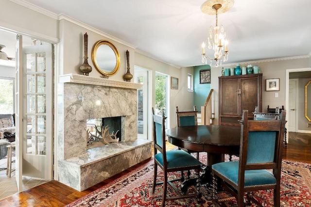 2606 Rockingham Dr, Austin, TX 78704 - dining area featuring a chandelier, crown molding, wood finished floors, stairway, and a high end fireplace
