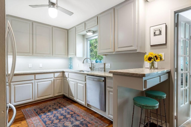 2606 Rockingham Dr, Austin, TX 78704 - kitchen featuring stainless steel dishwasher, refrigerator, dark wood-style floors, ceiling fan, and light stone counters