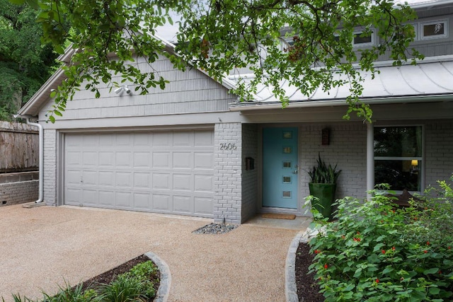2606 Rockingham Dr, Austin, TX 78704 - view of front of home featuring brick siding, driveway, and an attached garage