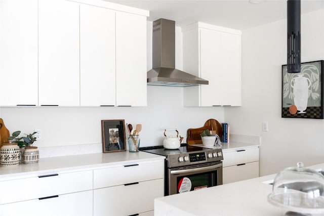 5731 Wellington Dr, Austin, TX 78723 - kitchen with wall chimney range hood, stainless steel electric stove, modern cabinets, and light countertops