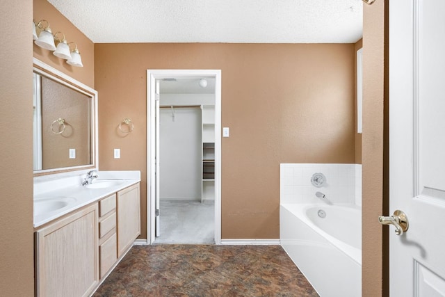 11978 Dorsett Rd, Austin, TX 78727 - bathroom with double vanity, a garden tub, a spacious closet, and a textured ceiling