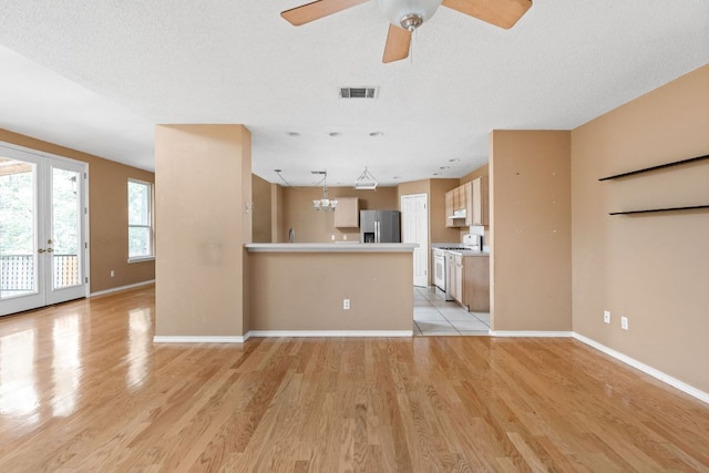 11978 Dorsett Rd, Austin, TX 78727 - unfurnished living room featuring light wood-style flooring, a ceiling fan, french doors, and a chandelier