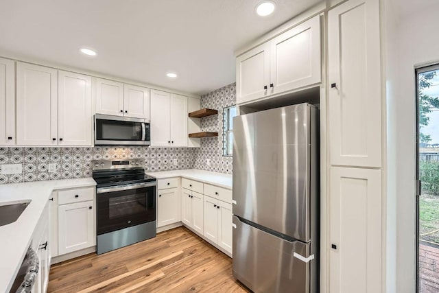 16825 Hamilton Point Cir, Manor, TX 78653 - kitchen featuring stainless steel appliances, open shelves, light wood-type flooring, tasteful backsplash, and white cabinetry