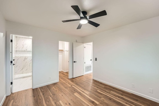 16825 Hamilton Point Cir, Manor, TX 78653 - unfurnished bedroom with a spacious closet, wood-type flooring, a closet, connected bathroom, and ceiling fan