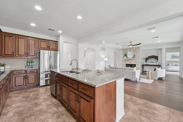 1508 Australis Cv, Austin, TX 78732 - kitchen with stainless steel appliances, arched walkways, ceiling fan, light stone countertops, and tasteful backsplash