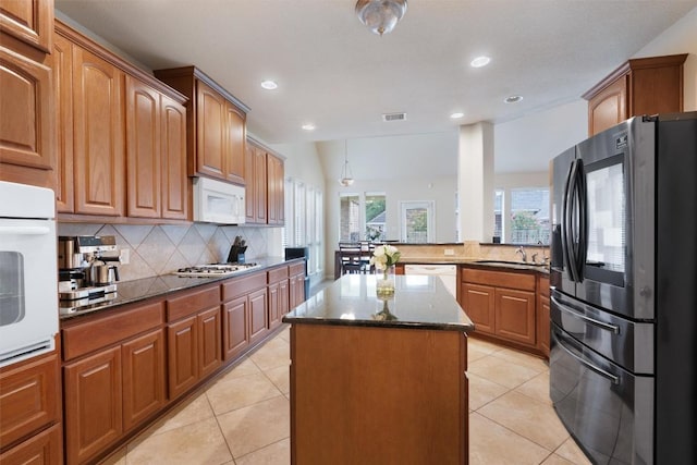 11404 Terrace Meadow Way, Manor, TX 78653 - kitchen featuring stainless steel appliances, tasteful backsplash, a kitchen island, recessed lighting, and dark stone counters