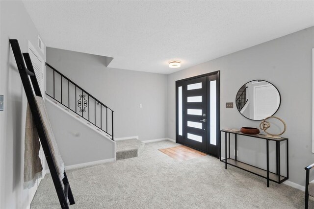 5317 Harvest Ln, Austin, TX 78745 - carpeted entryway with stairway and a textured ceiling
