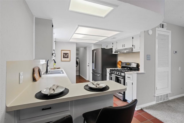 5317 Harvest Ln, Austin, TX 78745 - kitchen featuring stainless steel appliances, under cabinet range hood, light countertops, a peninsula, and white cabinetry