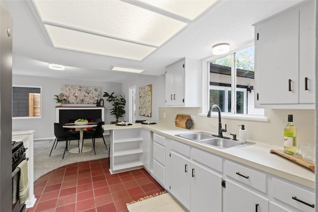 5317 Harvest Ln, Austin, TX 78745 - kitchen featuring stainless steel gas range oven, light countertops, white cabinets, dark tile patterned flooring, and a peninsula