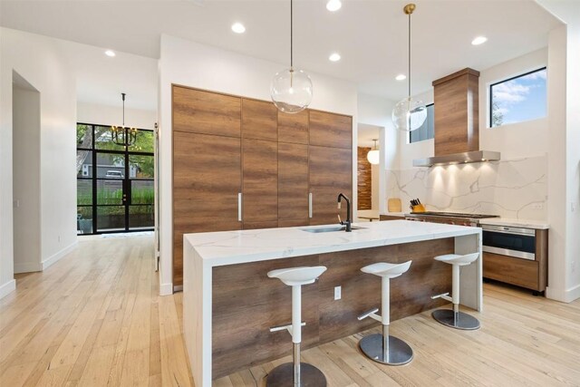 4103 Ridgelea Dr, Austin, TX 78731 - kitchen featuring modern cabinets, light wood-style floors, brown cabinetry, and recessed lighting