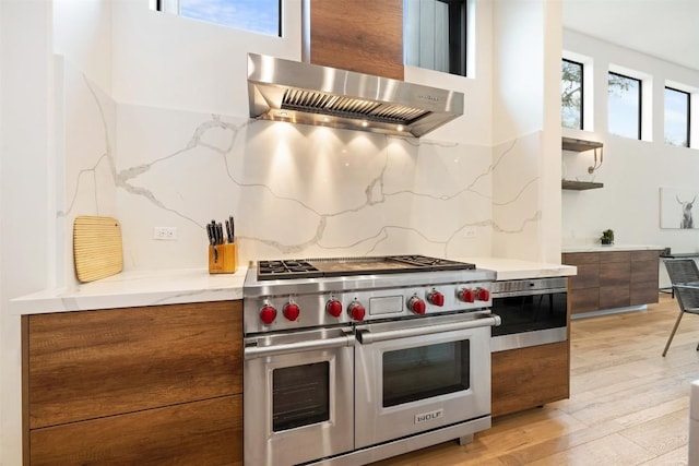 4103 Ridgelea Dr, Austin, TX 78731 - kitchen featuring range with two ovens, modern cabinets, brown cabinetry, ventilation hood, and open shelves