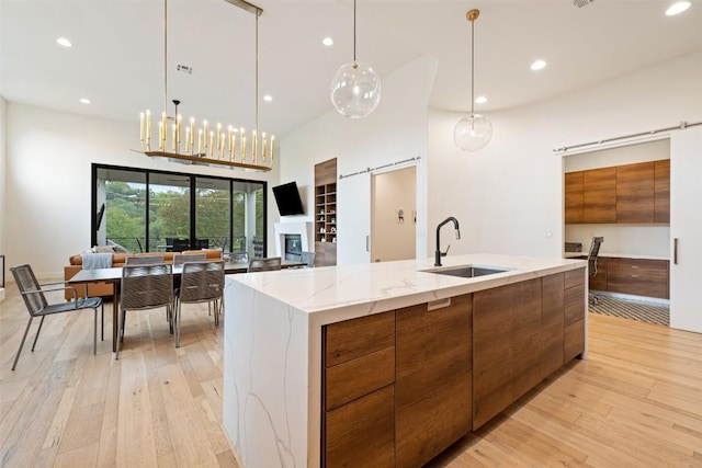 4103 Ridgelea Dr, Austin, TX 78731 - kitchen featuring modern cabinets, brown cabinetry, open floor plan, recessed lighting, and light wood-type flooring