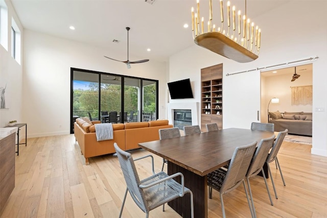 4103 Ridgelea Dr, Austin, TX 78731 - dining space with a high ceiling, recessed lighting, light wood-type flooring, a glass covered fireplace, and a ceiling fan
