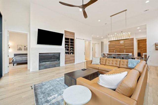 4103 Ridgelea Dr, Austin, TX 78731 - living area with light wood-style floors, ceiling fan, recessed lighting, and a glass covered fireplace