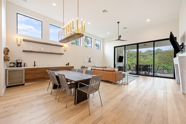 4103 Ridgelea Dr, Austin, TX 78731 - dining space featuring wine cooler, wet bar, light wood-style flooring, recessed lighting, and a towering ceiling