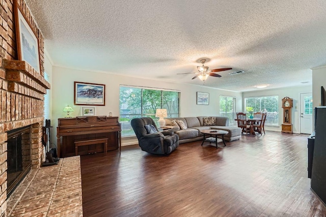 12711 Possum Hollow Dr, Austin, TX 78729 - living room featuring a brick fireplace, ceiling fan, a textured ceiling, and wood finished floors
