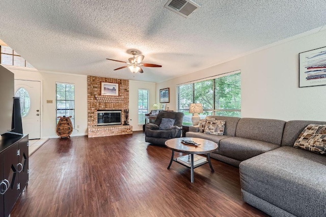 12711 Possum Hollow Dr, Austin, TX 78729 - living area with dark wood-style floors, a textured ceiling, a ceiling fan, a fireplace, and ornamental molding