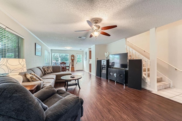 12711 Possum Hollow Dr, Austin, TX 78729 - living area with stairway, a textured ceiling, wood finished floors, ceiling fan, and ornamental molding