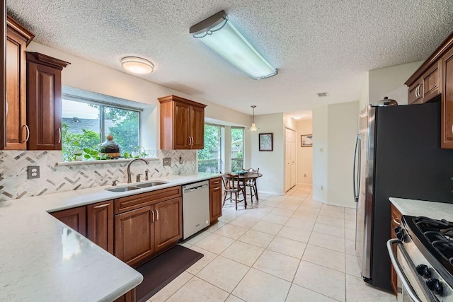12711 Possum Hollow Dr, Austin, TX 78729 - kitchen featuring appliances with stainless steel finishes, decorative backsplash, light countertops, light tile patterned flooring, and decorative light fixtures