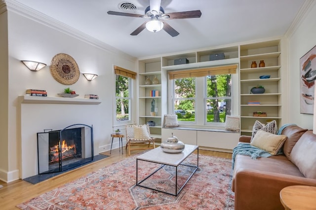 2702 Bonnie Rd, Austin, TX 78703 - living room featuring crown molding, built in shelves, wood finished floors, and a lit fireplace