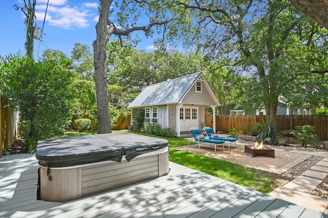 2702 Bonnie Rd, Austin, TX 78703 - wooden deck featuring a hot tub, a fire pit, a fenced backyard, and an outbuilding